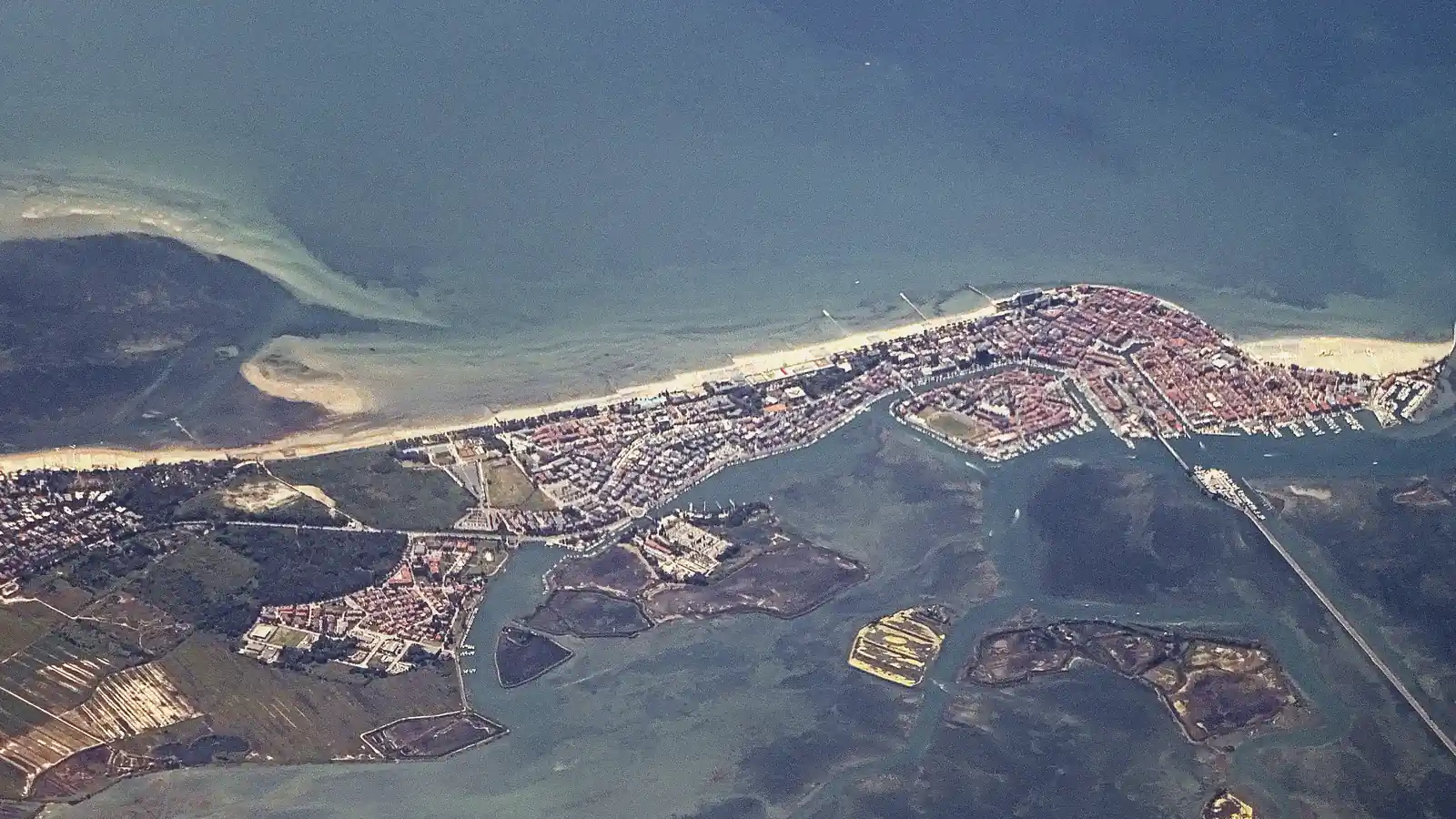 Grado from the air: the town on its island between the open sea and the lagoon.