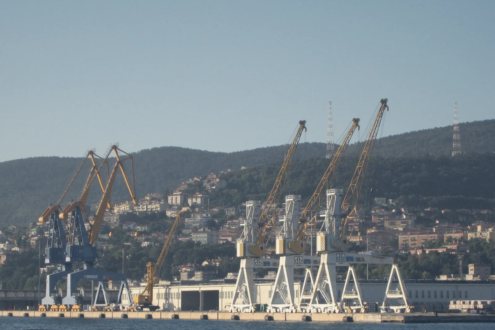 The cranes of the commercial port of Trieste against the sky.